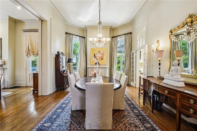 dining room with a chandelier, dark wood-type flooring, and ornamental molding