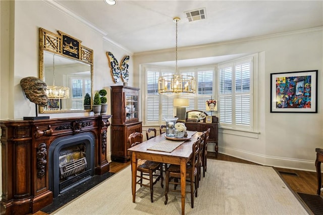 dining room featuring a chandelier, hardwood / wood-style flooring, and ornamental molding