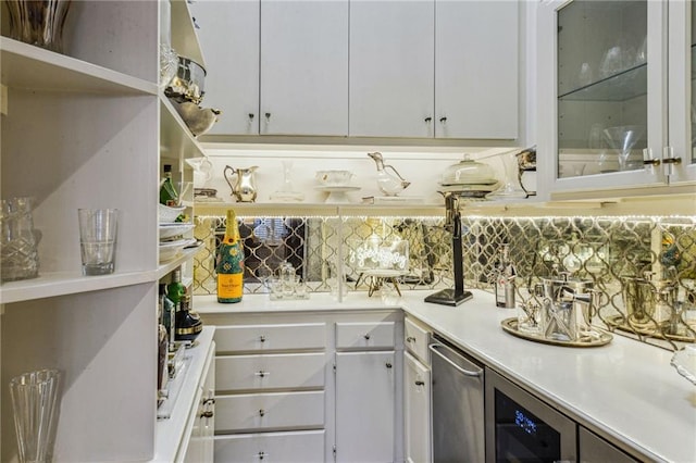 bar featuring white cabinetry, backsplash, and beverage cooler