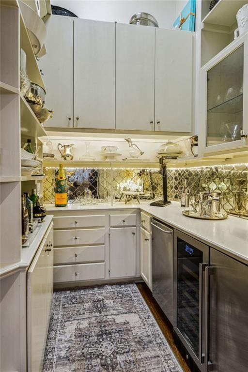 kitchen with decorative backsplash, dishwasher, and white cabinetry