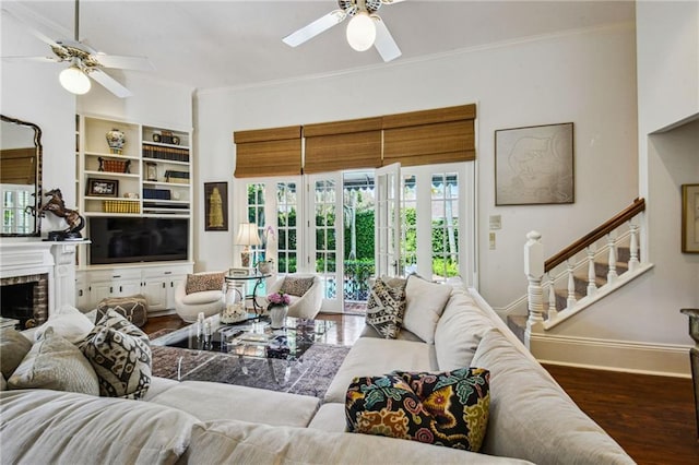 living room featuring a fireplace, hardwood / wood-style flooring, ceiling fan, and crown molding