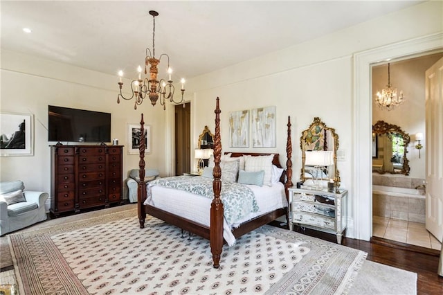 bedroom with ensuite bath, a notable chandelier, and hardwood / wood-style flooring