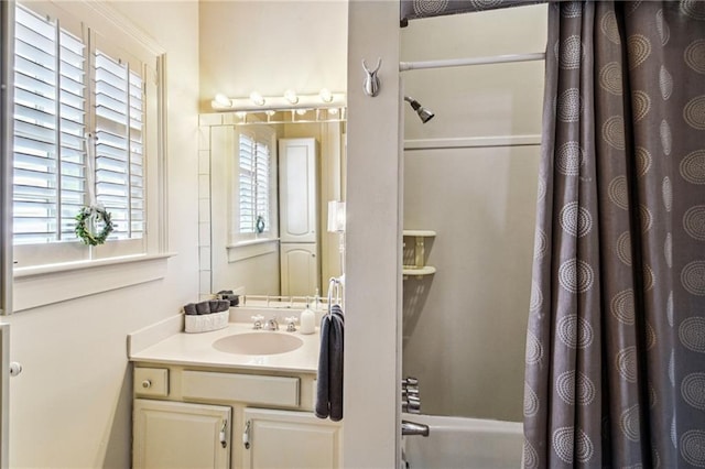 bathroom with vanity, shower / bathtub combination with curtain, and a wealth of natural light