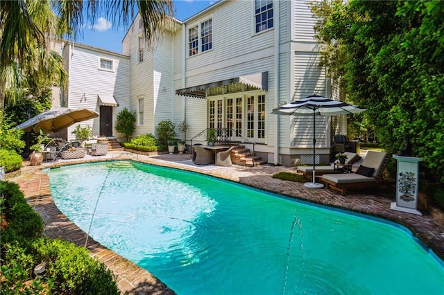 back of property with an outdoor living space and french doors