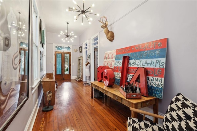 entrance foyer featuring dark wood-type flooring, a notable chandelier, and french doors