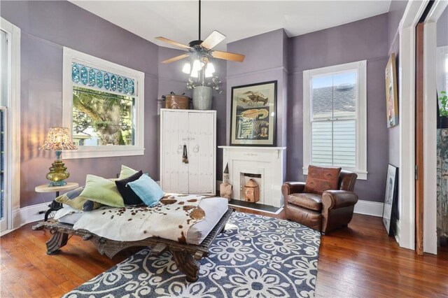 sitting room featuring a wealth of natural light, ceiling fan, and dark hardwood / wood-style flooring