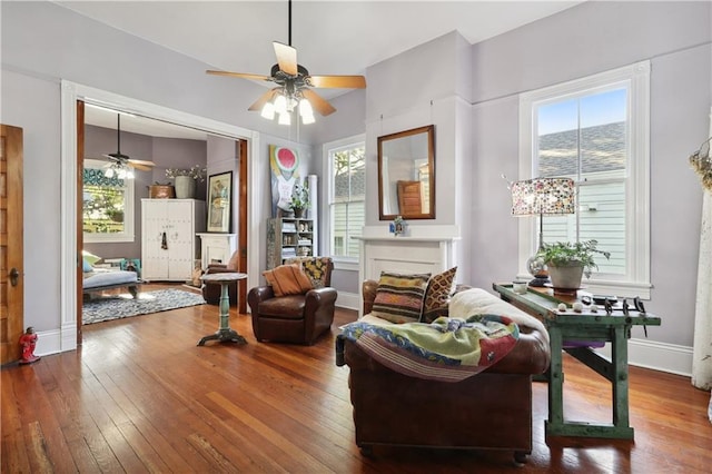 living area with ceiling fan, a healthy amount of sunlight, and hardwood / wood-style flooring