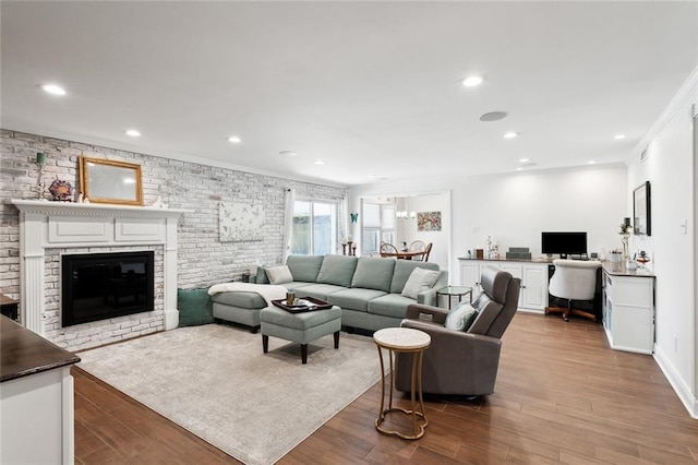 living room featuring a brick fireplace and light hardwood / wood-style floors