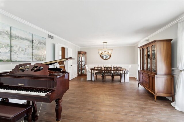 misc room with a notable chandelier, ornamental molding, and hardwood / wood-style flooring