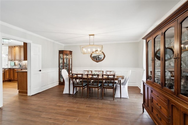 dining room with a notable chandelier, dark hardwood / wood-style flooring, and ornamental molding