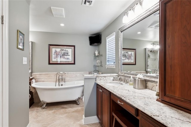 bathroom featuring a washtub, tile patterned floors, and vanity