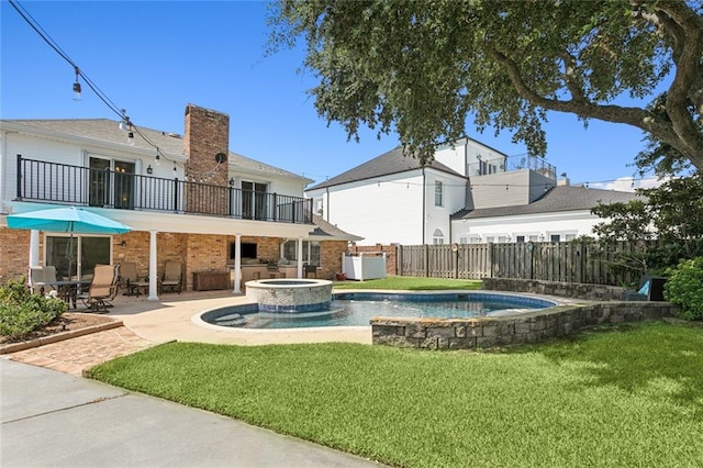 view of pool with a lawn, an in ground hot tub, and a patio area