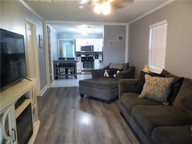 living room featuring ceiling fan, ornamental molding, and hardwood / wood-style flooring