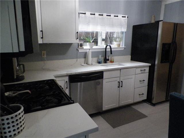 kitchen featuring appliances with stainless steel finishes, sink, and white cabinetry