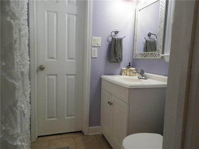 bathroom with toilet, tile patterned floors, and vanity