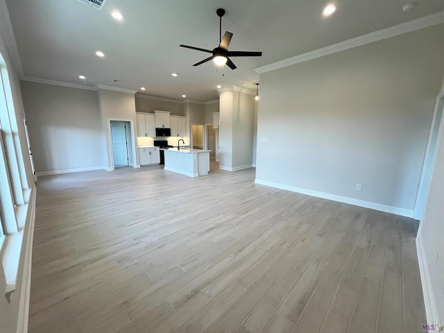 unfurnished living room featuring light wood-type flooring, a sink, recessed lighting, baseboards, and ceiling fan