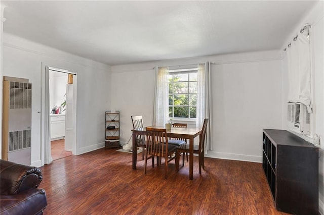 dining space with baseboards, a heating unit, and dark wood-type flooring