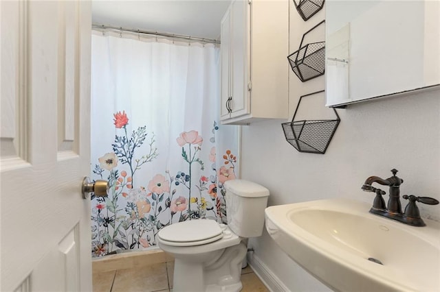 bathroom featuring a sink, toilet, and tile patterned floors