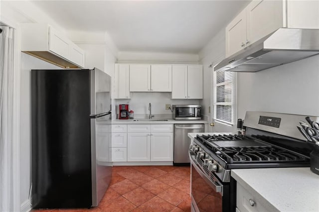 kitchen with under cabinet range hood, a sink, white cabinets, light countertops, and appliances with stainless steel finishes