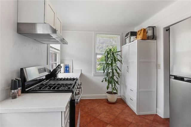 kitchen featuring under cabinet range hood, white cabinetry, baseboards, light countertops, and stainless steel gas stove