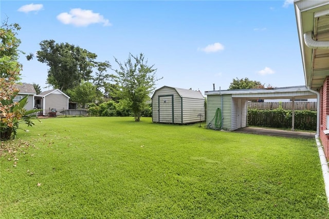 view of yard featuring a shed, fence, and an outdoor structure