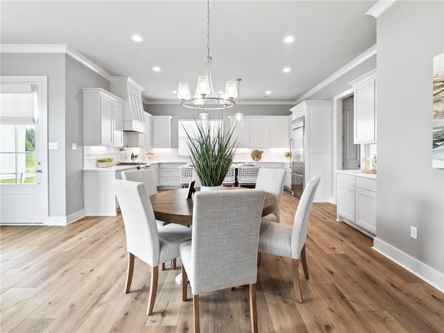 dining space with crown molding, a chandelier, and light hardwood / wood-style floors