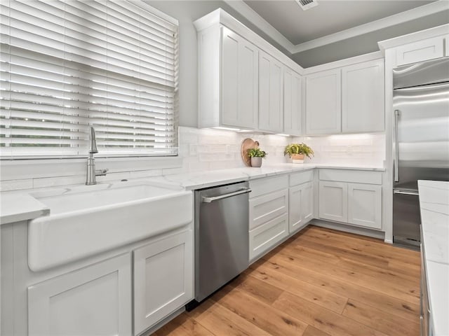 kitchen featuring white cabinetry, stainless steel appliances, sink, and backsplash