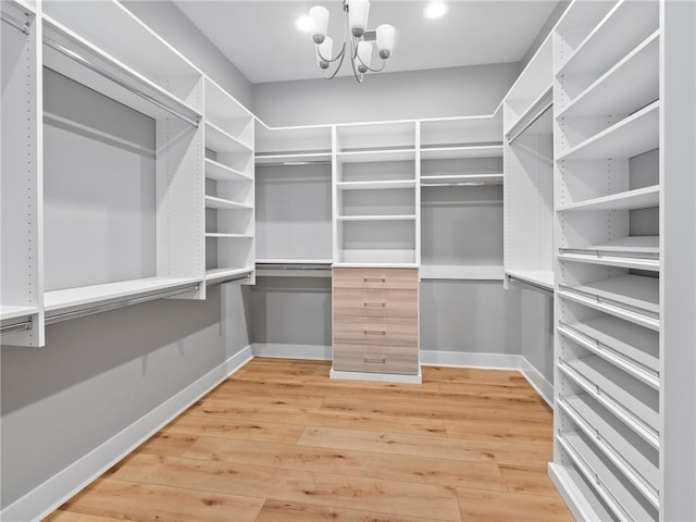 spacious closet featuring hardwood / wood-style flooring and a notable chandelier