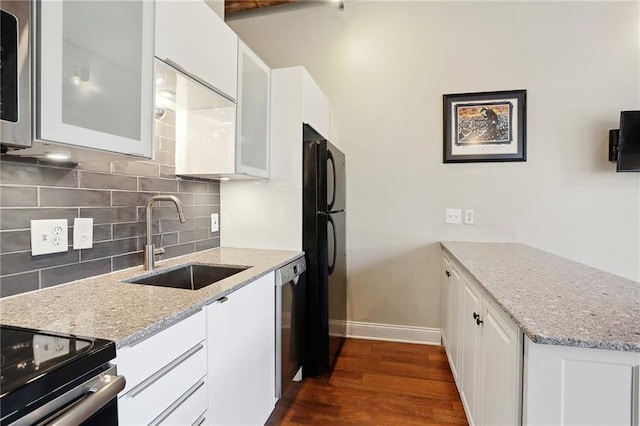 kitchen with white cabinetry, dark wood-type flooring, backsplash, stainless steel appliances, and sink