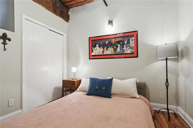 bedroom with beamed ceiling and wood-type flooring