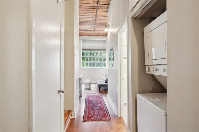 laundry room featuring light hardwood / wood-style flooring and stacked washer and clothes dryer