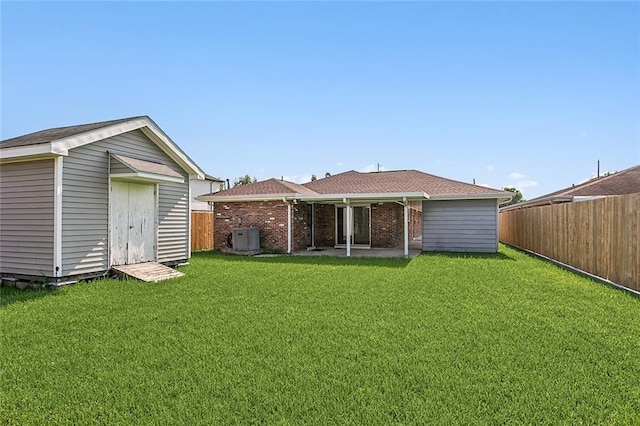 rear view of house with a lawn, a storage unit, a patio, and central air condition unit