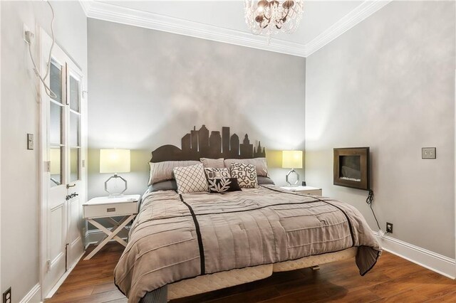 719 St Ann St Unit 2, New Orleans, LA 70116 - bedroom with ornamental molding, wood finished floors, baseboards, and a chandelier