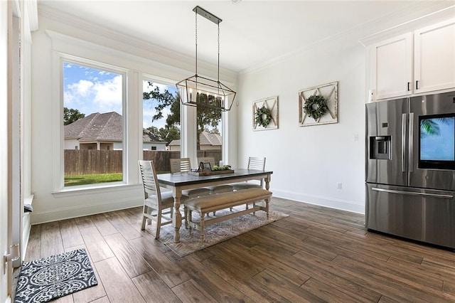 dining area featuring ornamental molding, dark wood-type flooring, and an inviting chandelier