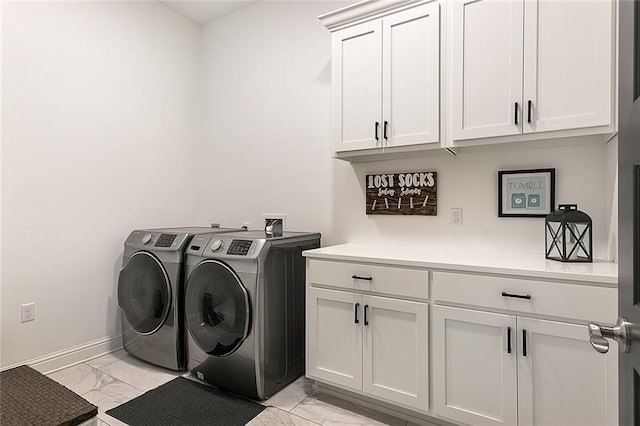 washroom featuring light tile patterned flooring, cabinets, and washer and dryer