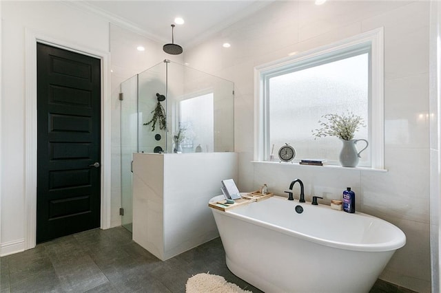 bathroom with crown molding, tile walls, tile patterned flooring, and separate shower and tub