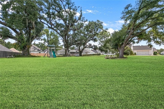 view of yard featuring a garage and a playground