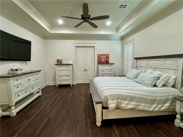 bedroom featuring ceiling fan, dark wood-type flooring, a raised ceiling, and crown molding