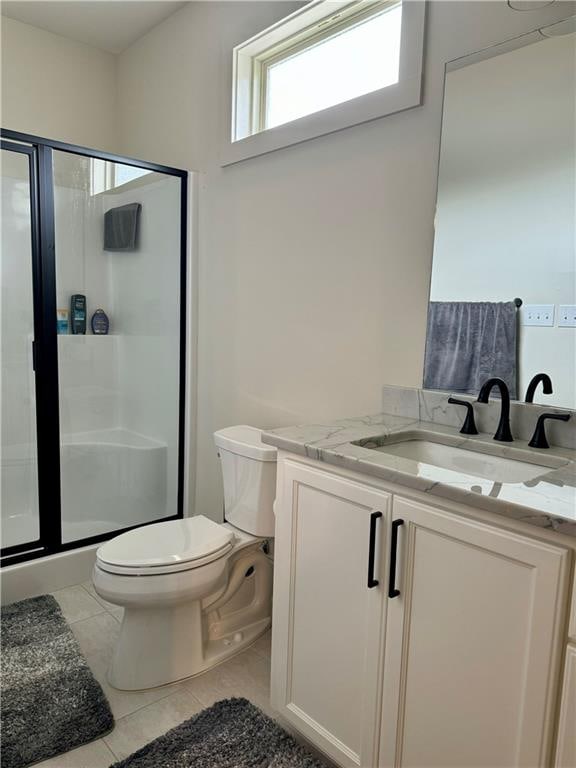 bathroom with tile patterned floors, an enclosed shower, vanity, and toilet