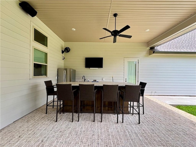 view of patio with ceiling fan and an outdoor wet bar