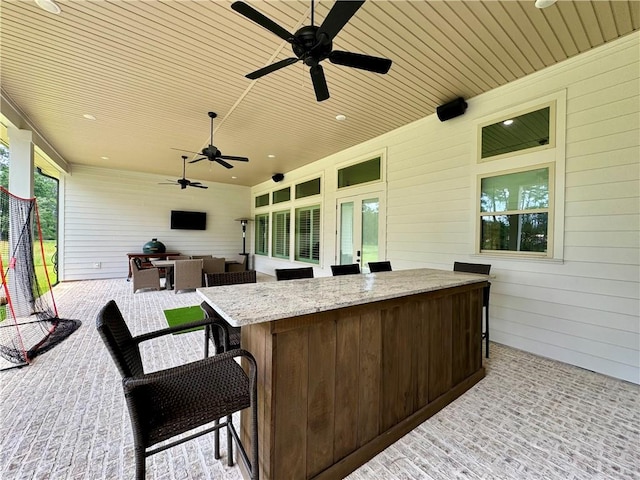 view of patio with ceiling fan and an outdoor bar