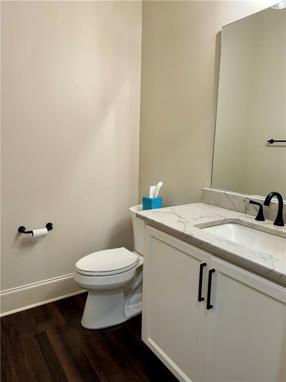 bathroom featuring wood-type flooring, toilet, and vanity