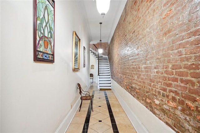 corridor featuring brick wall and light tile patterned floors