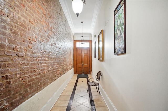 hall featuring crown molding, light tile patterned flooring, and brick wall