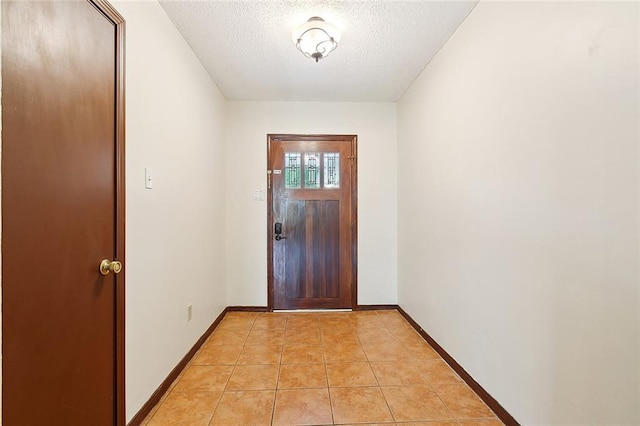 foyer entrance with light tile patterned floors and a textured ceiling