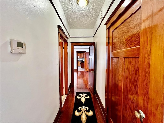 corridor featuring a textured ceiling and dark hardwood / wood-style floors