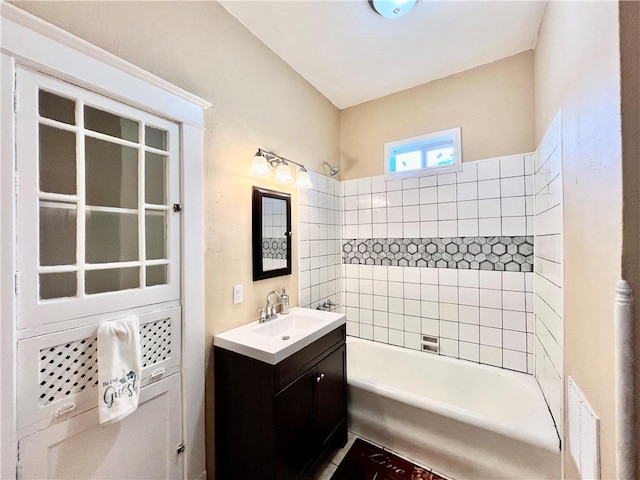 bathroom featuring tiled shower / bath combo and vanity