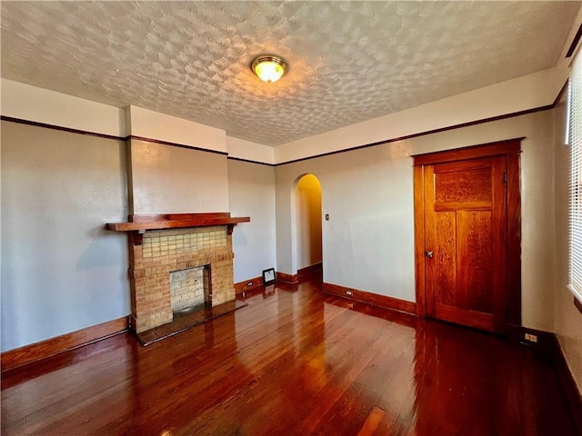 unfurnished living room featuring a fireplace, hardwood / wood-style floors, and a textured ceiling