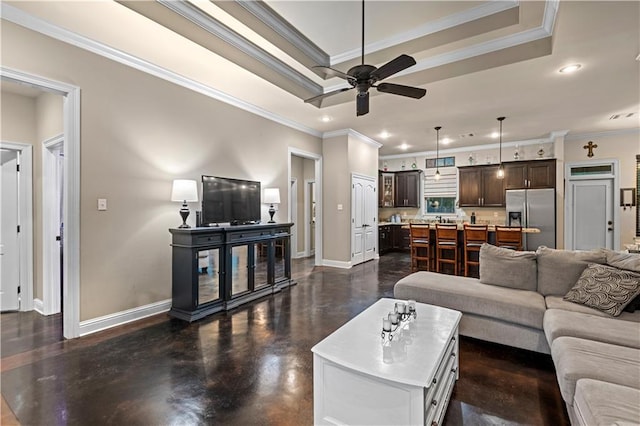 living room featuring crown molding, ceiling fan, and a tray ceiling