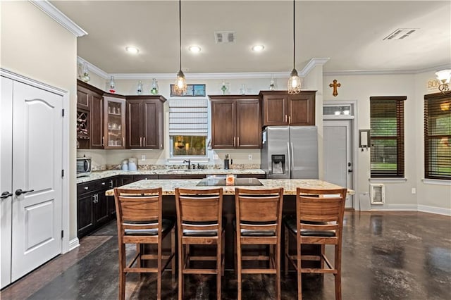 kitchen featuring stainless steel appliances, a center island, hanging light fixtures, and dark brown cabinets